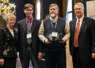 Brian Deal and three other people standing with award