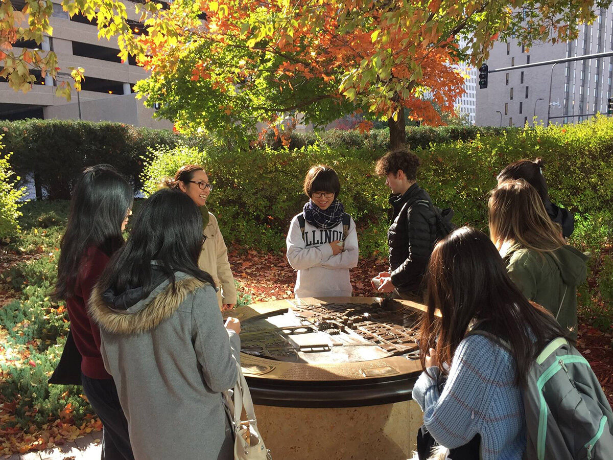 Satoko Muratake of firm Ten x Ten talking with students in a park in Minneapolis