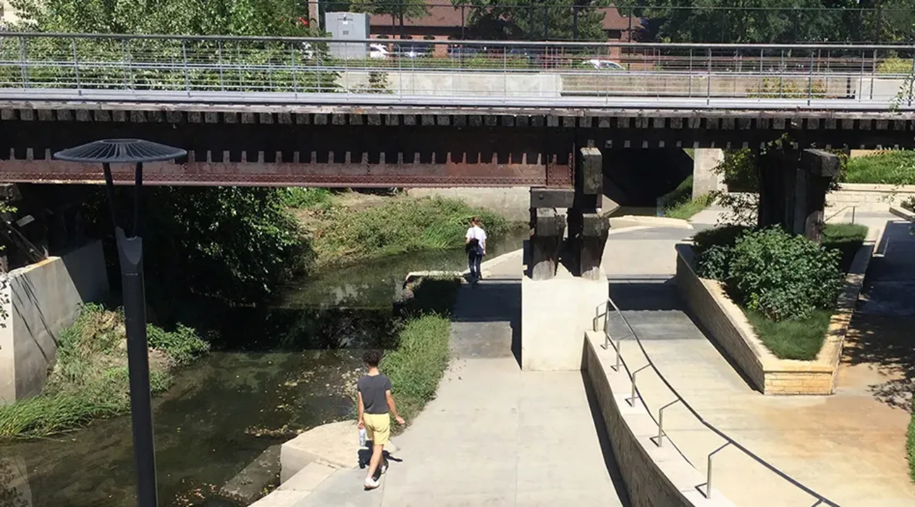 View of students exploring public open space around Boneyard Creek in downtown Urbana, IL