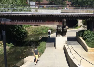 View of students exploring public open space around Boneyard Creek in downtown Urbana, IL