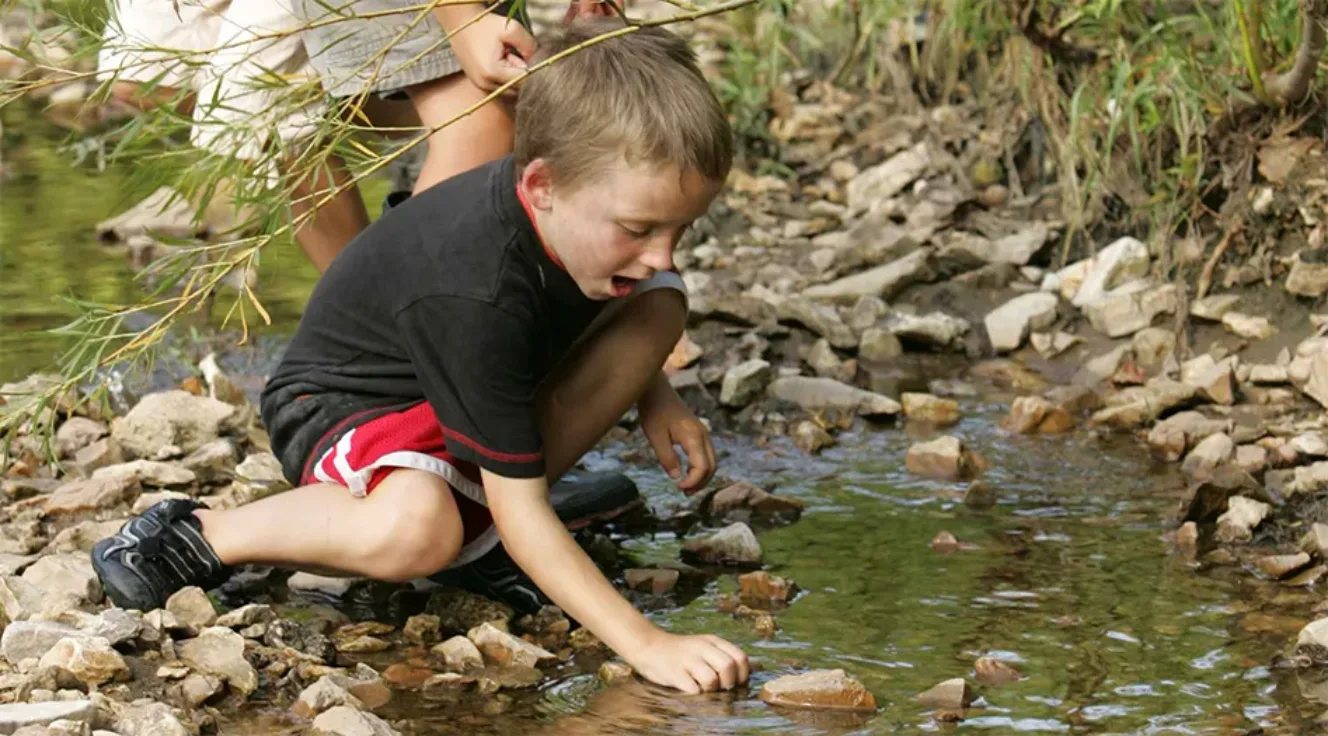 Photo of a boy playing in a stream