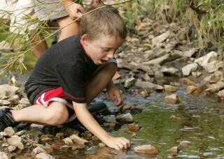 Photo of a boy playing in a stream