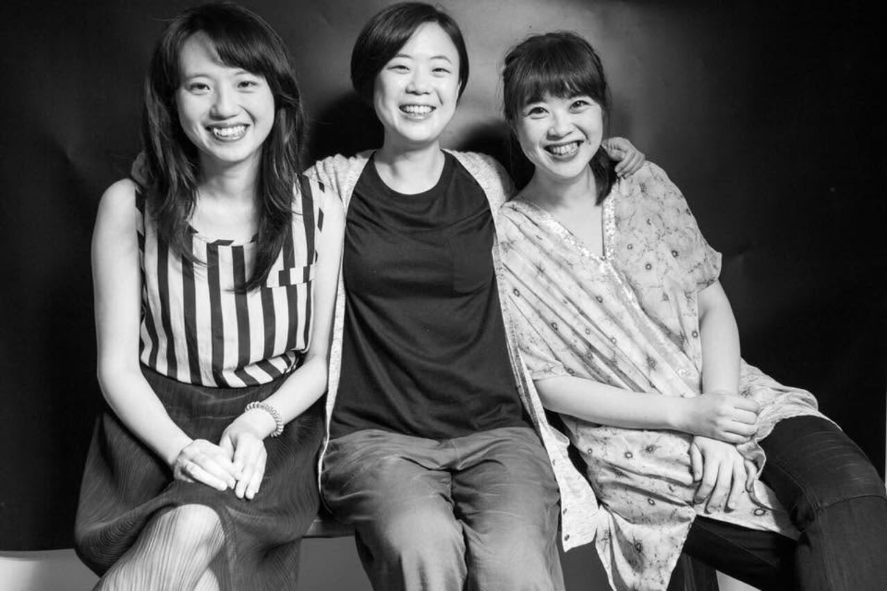 The Formosa Trio huddled in a group, smiling