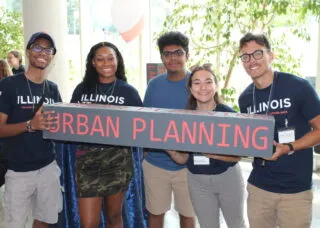 5 students standing holding "urban planning" sign
