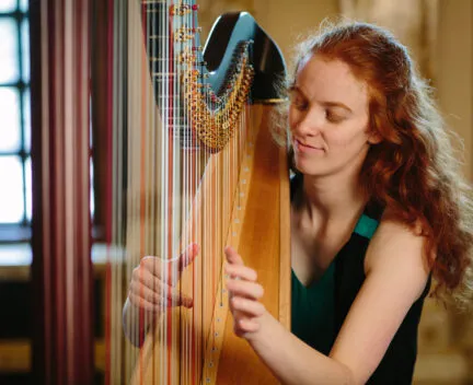 a student plays the harp