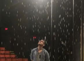 student standing on stage in rain