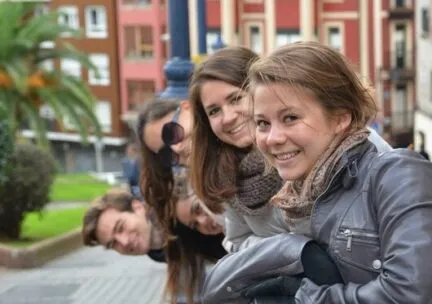 students leaning over ledge and smiling