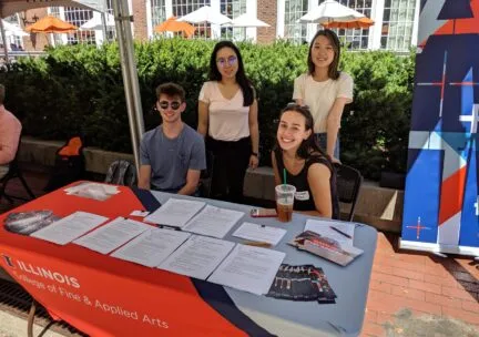 4 students next to shaded table with FAA branding