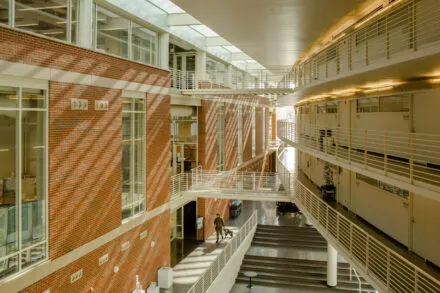 inside of building, red brick on one wall, open atrium three stories high