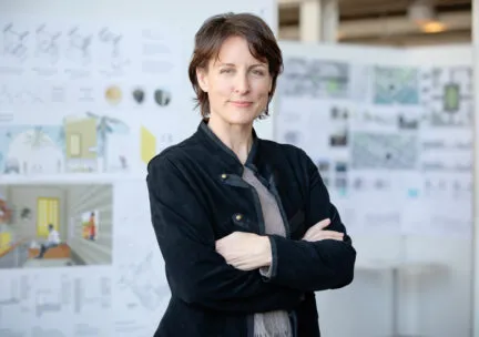 person with arms crossed looking at camera with blurred background