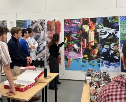 a student presents a design project with lots of students watching