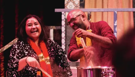 two people cooking food over a stove