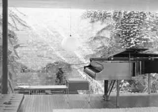 Black and white photo of interior of a house with a piano