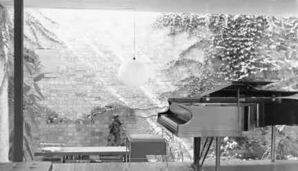 Black and white photo of interior of a house with a piano