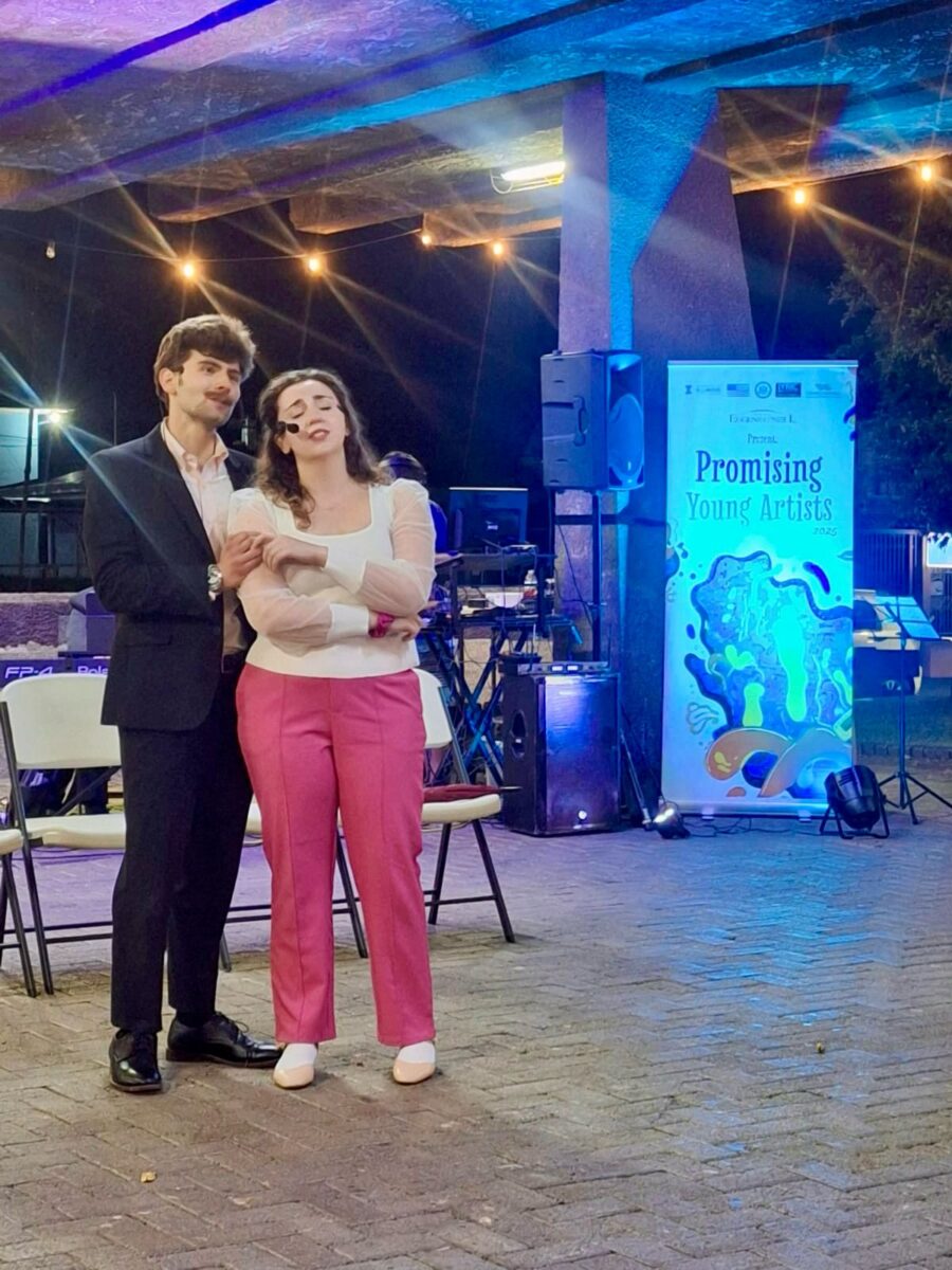 2 people holding hands and singing