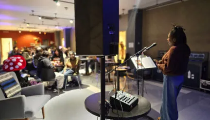 Person speaking on mic in front of an audience