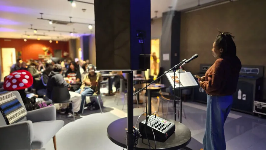 Person speaking on mic in front of an audience