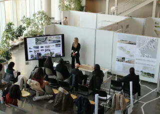 students gathered around big white boards