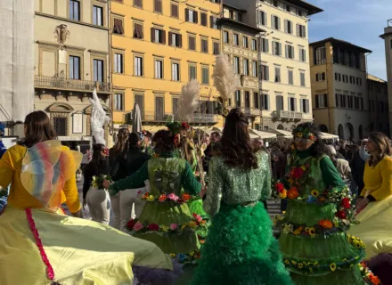 several people dressed in bright colors in a city plaza