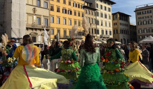 several people dressed in bright colors in a city plaza