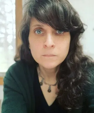 Image of person with dark brown hair in a green sweater