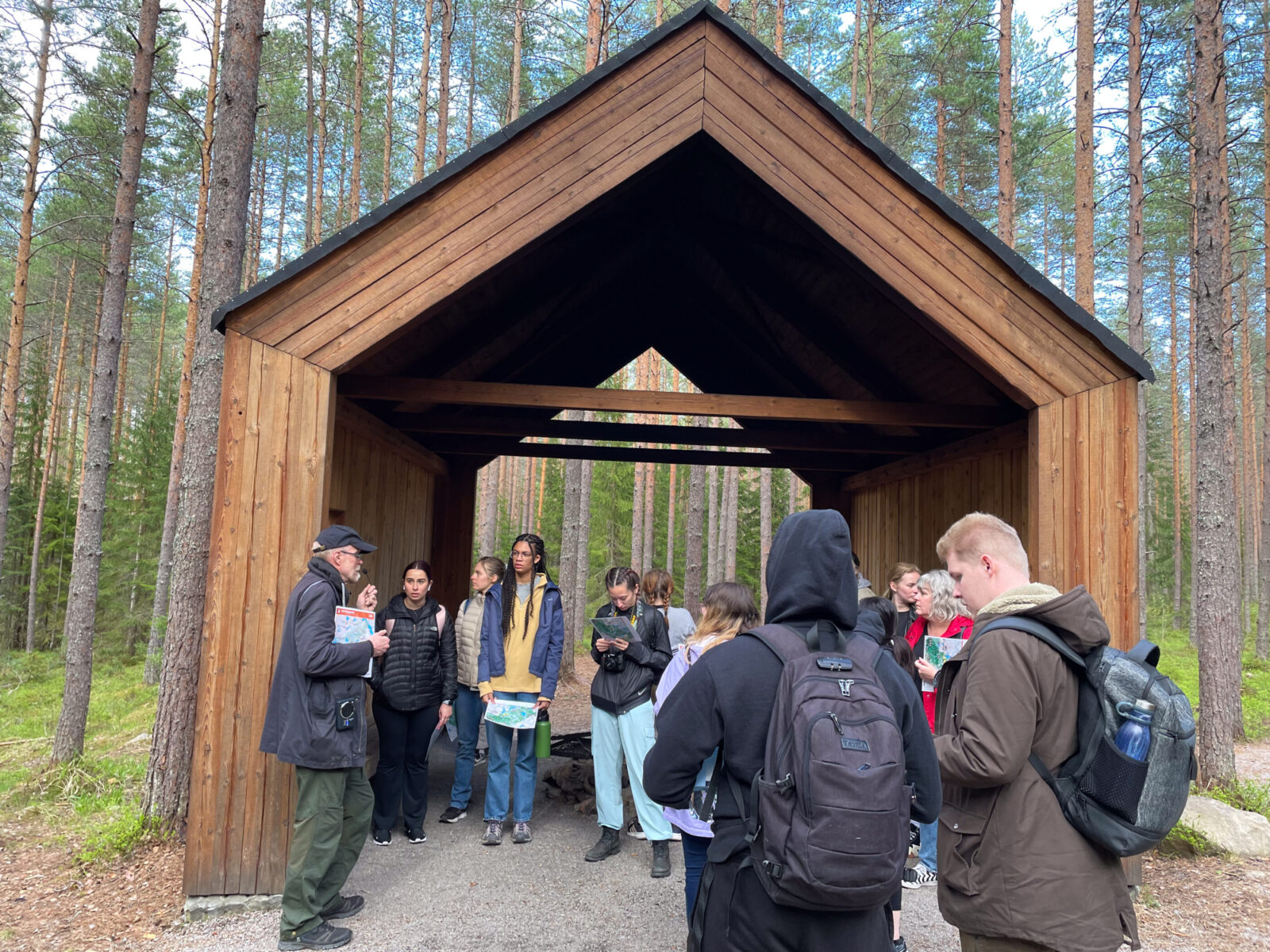 people in forest landscape under house shaped cover