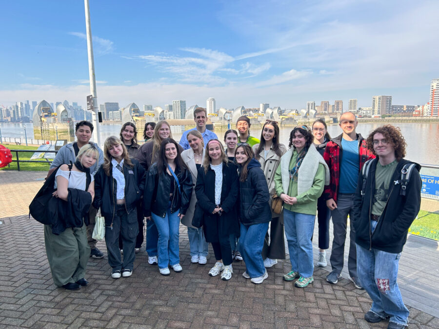 Group of people posing in front of water and skyline