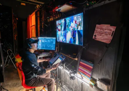 tech person works backstage on an immersive production with video