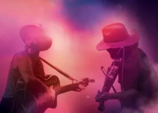 two people playing instrument under bright lights and stage fog
