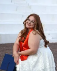 person sits with graduation gear on
