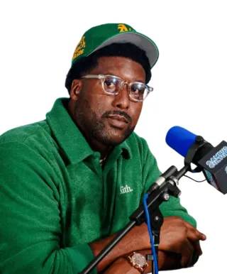 person wearing green shirt and hat and talking into a blue microphone