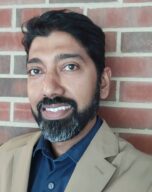 Photo of Prof. Arnab Chakraborty standing in front of a brick wall