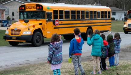 Photo of students waving to school bus