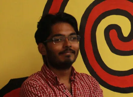 Efadul Huq in front of yellow wall with orange swirl