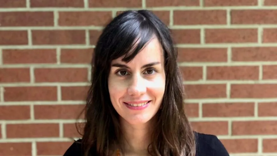 Photo of Professor Novoa in front of a red brick wall