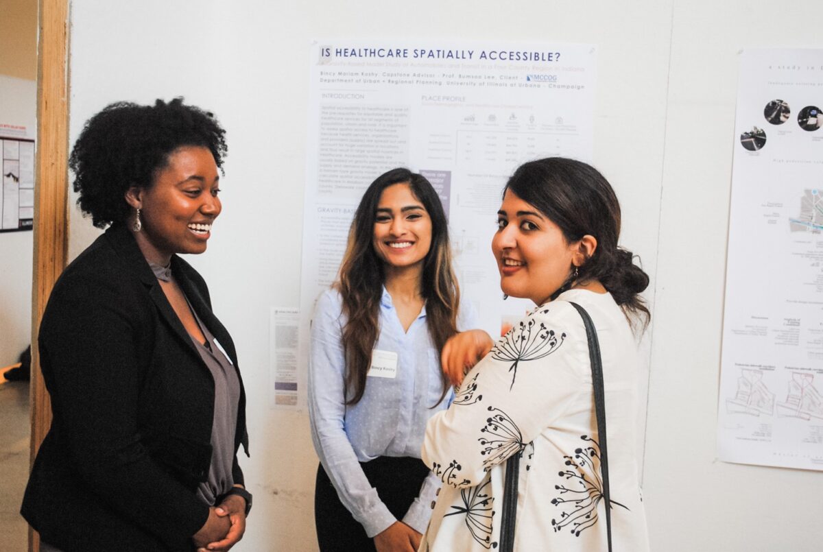 three people talking in front of a poster