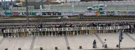Row of people holding a long sing in protest during the Chilean National Heritage Day.