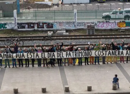 Row of people holding a long sing in protest during the Chilean National Heritage Day.