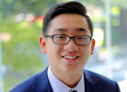 Photo of Zishen Ye in blue suit in front of window to outside.