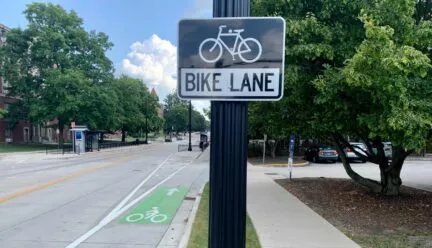 Photo of bike lane sign and actually bike lane along side of a rode on UIUC campus