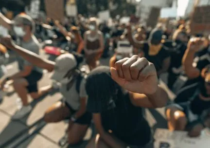 crowd with people holding one fist up