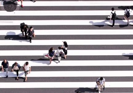 people walking atop a black and white striped street