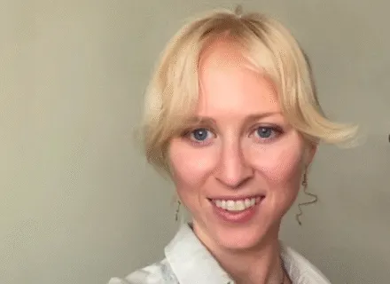 Photo of Rebecca in front of a white wall