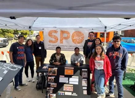 Group photo of SPO members under a tent outside