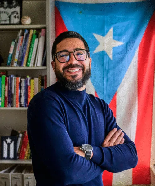 Photo of Omar Perez Figueroa in front of flag