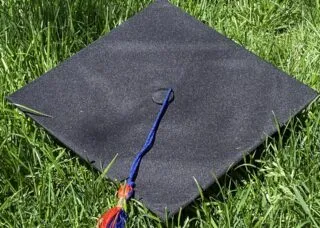 Photo of graduation cap on green grass