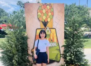 fang standing in from of disney sign