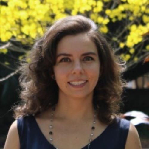 Photo of Julia Paiva outside in front of a green tree