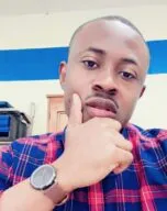 Photo of Dennis Arthur in classroom with blue plaid shirt