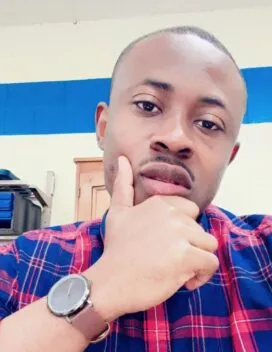 Photo of Dennis Arthur in classroom with blue plaid shirt